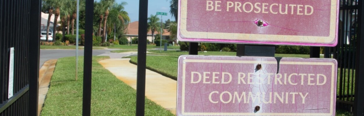 A sign on the gate of a deed restricted community