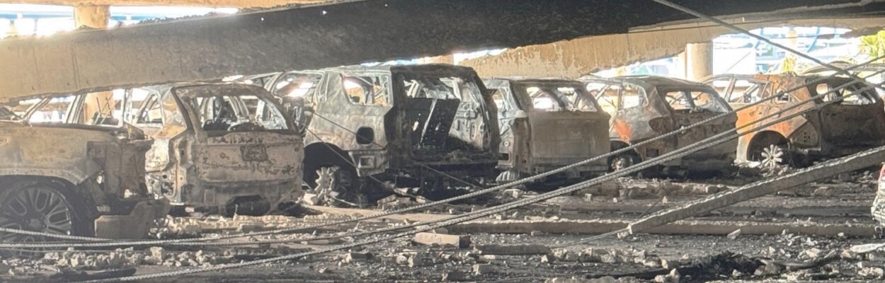 A row of burned vehicles in Jacksonville International Airport parking garage.