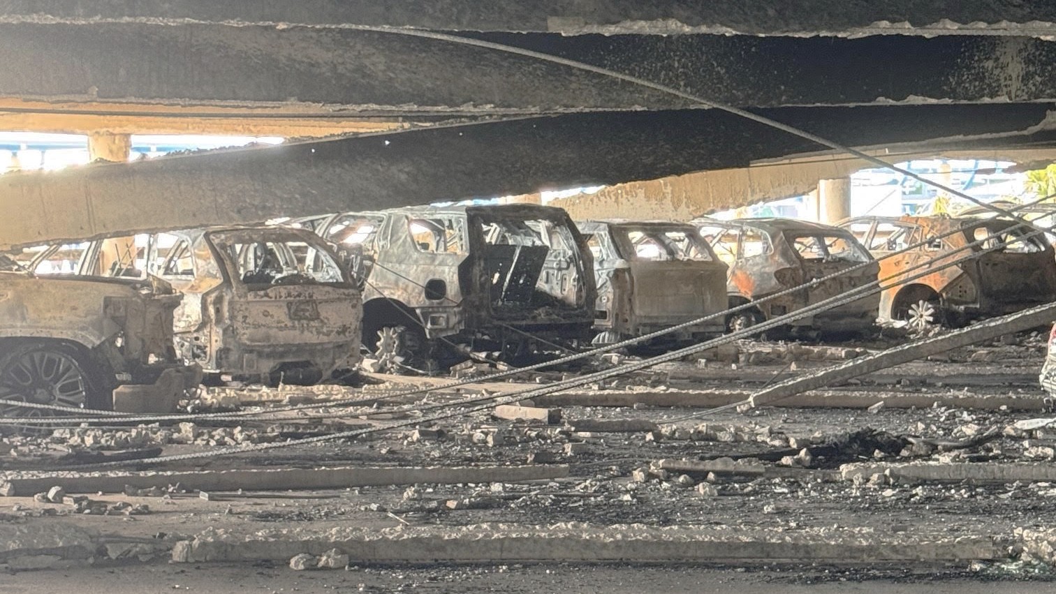 A row of burned vehicles in Jacksonville International Airport parking garage.