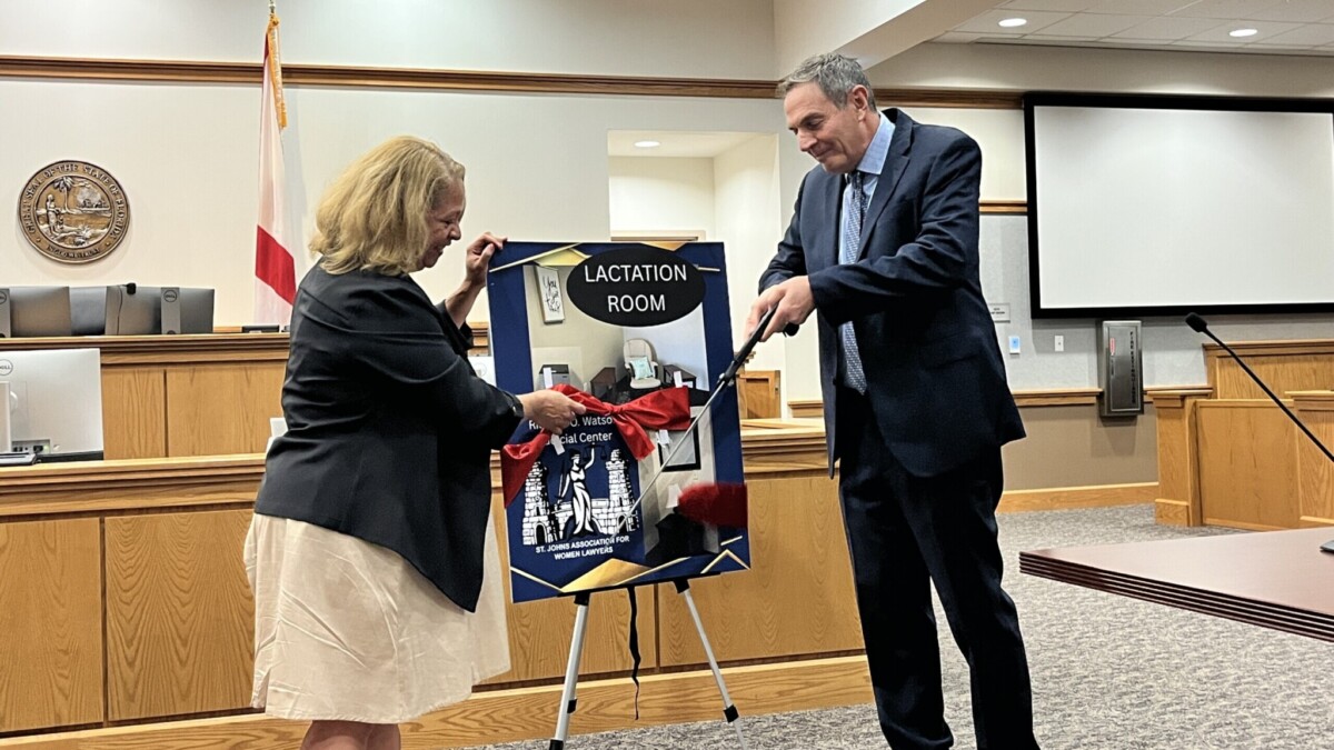 Ingrid Osborn, president of the St. Johns Association for Women Lawyers, and Circuit Judge Howard Maltz cut the ceremonial ribbon on a space for nursing and taking care of babies in the St. Johns County Courthouse