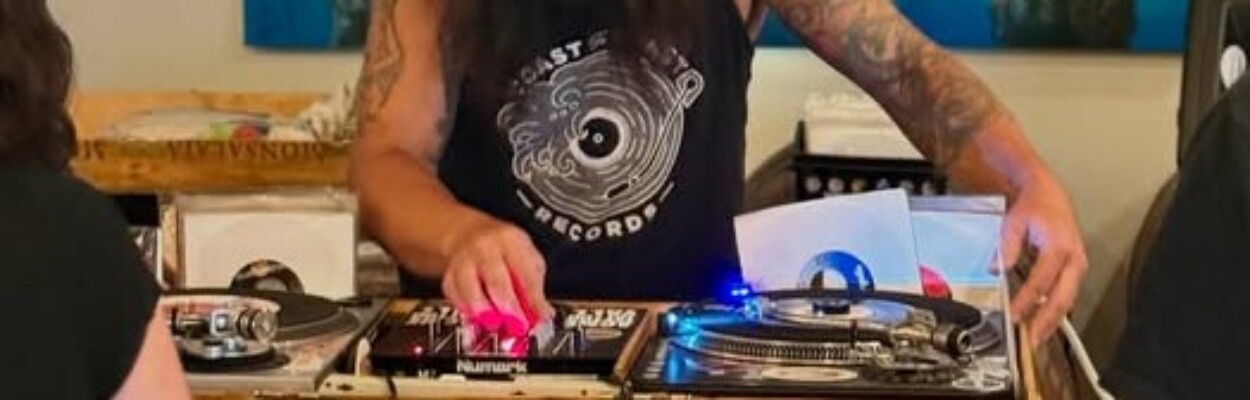 man standing behind turntables