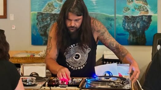man standing behind turntables