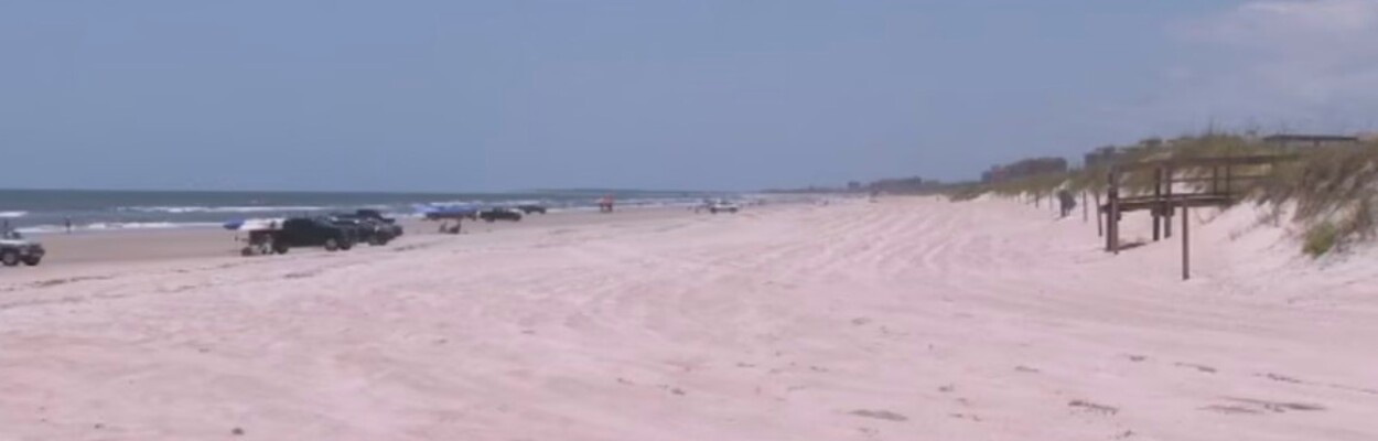 Cars parked on American Beach, as beach driving is allowed