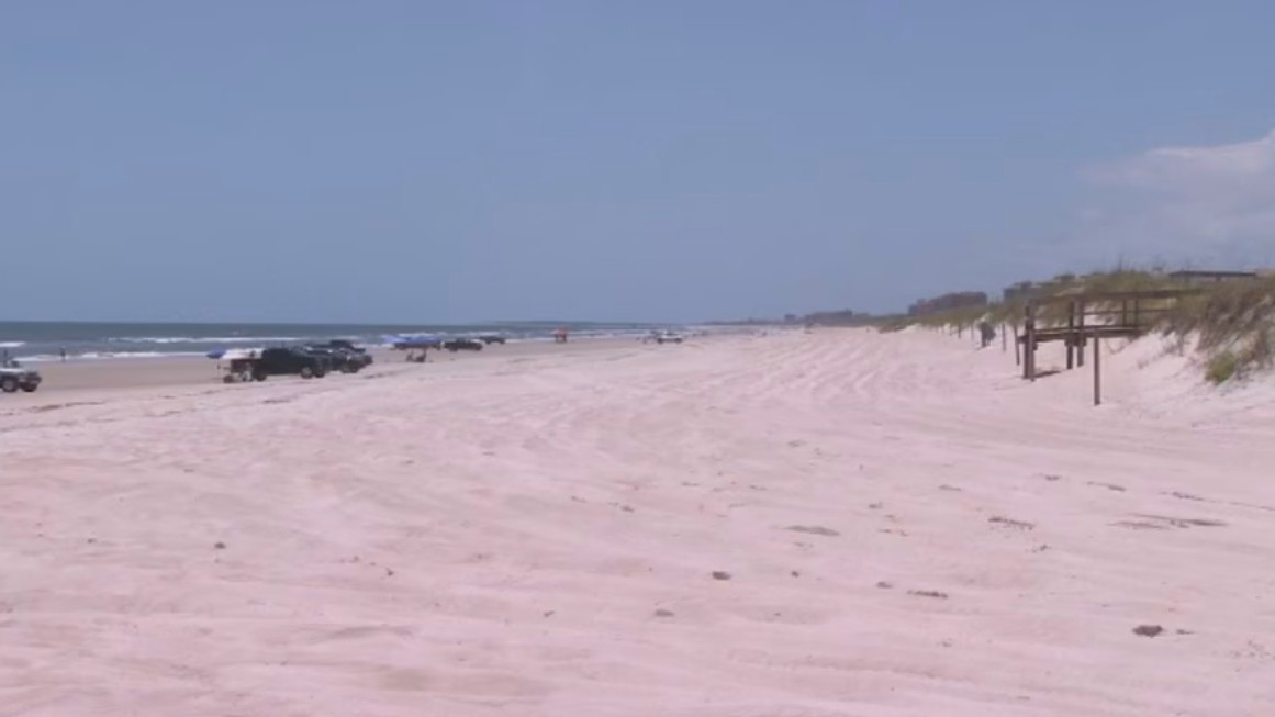 Cars parked on American Beach, as beach driving is allowed