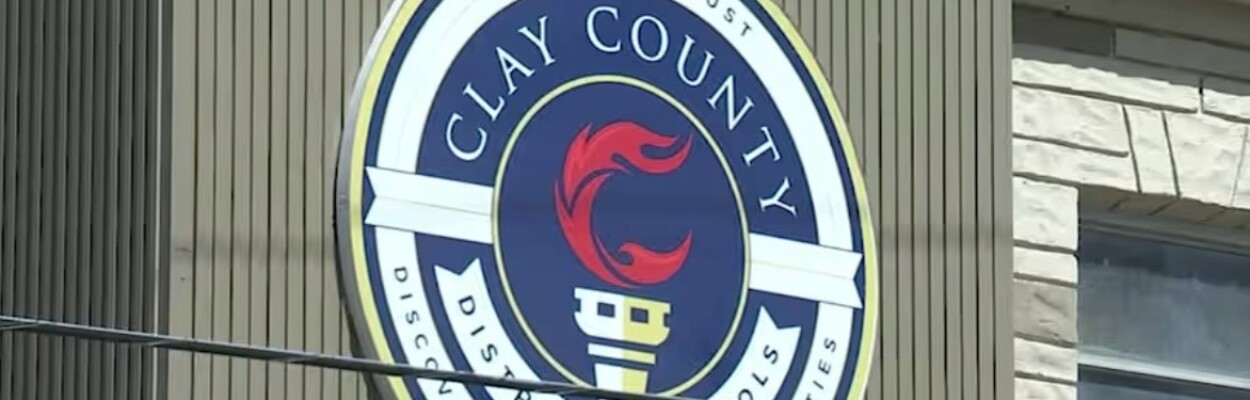 The Clay County school district emblem hangs on a building