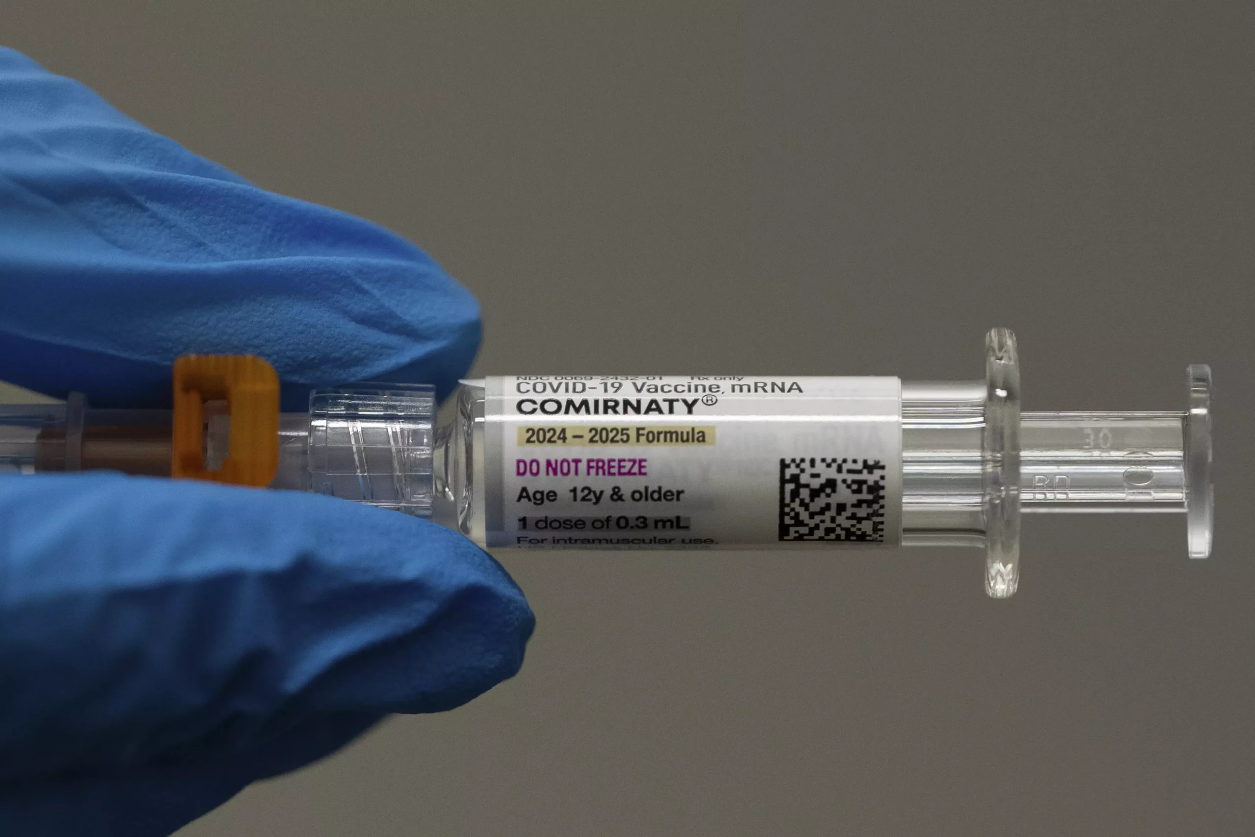 A pharmacist holds a Pfizer and BioNTech COVID-19 vaccine shot