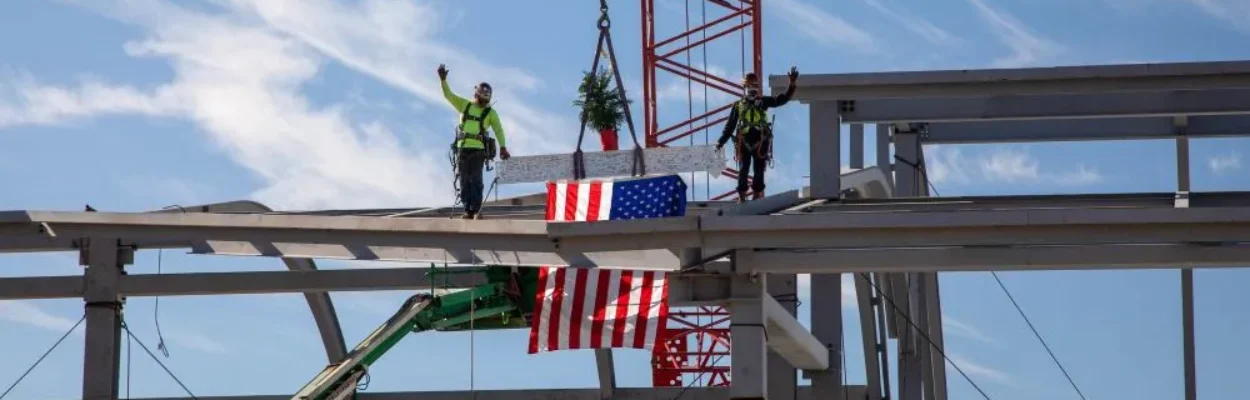 Contractors place a tree and American flag atop the last girder of Concourse B at Jacksonville International Airport.