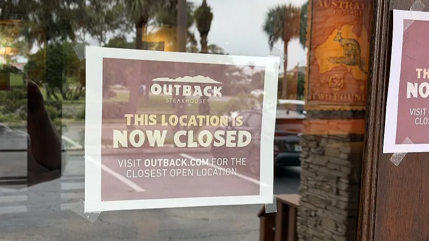 Signs on the door of Outback Steakhouse say it has closed.