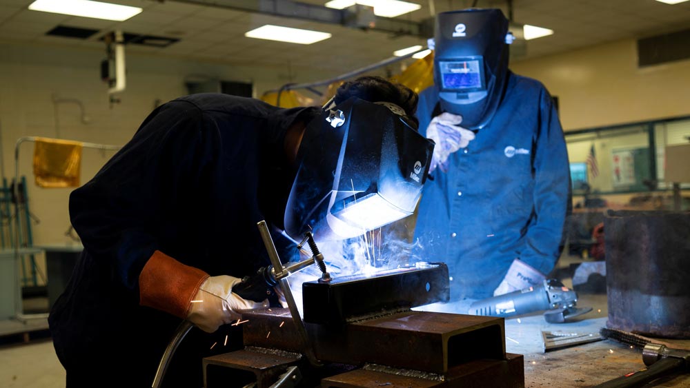 Two CTE students welding