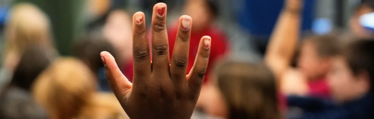 A student raises her hand in a classroom where history of communism may be taught.