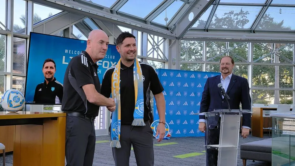 Sporting Jax's new men's soccer coach, Liam Fox, shakes hands with Sporting Jax's head of soccer, Mark Warburton.