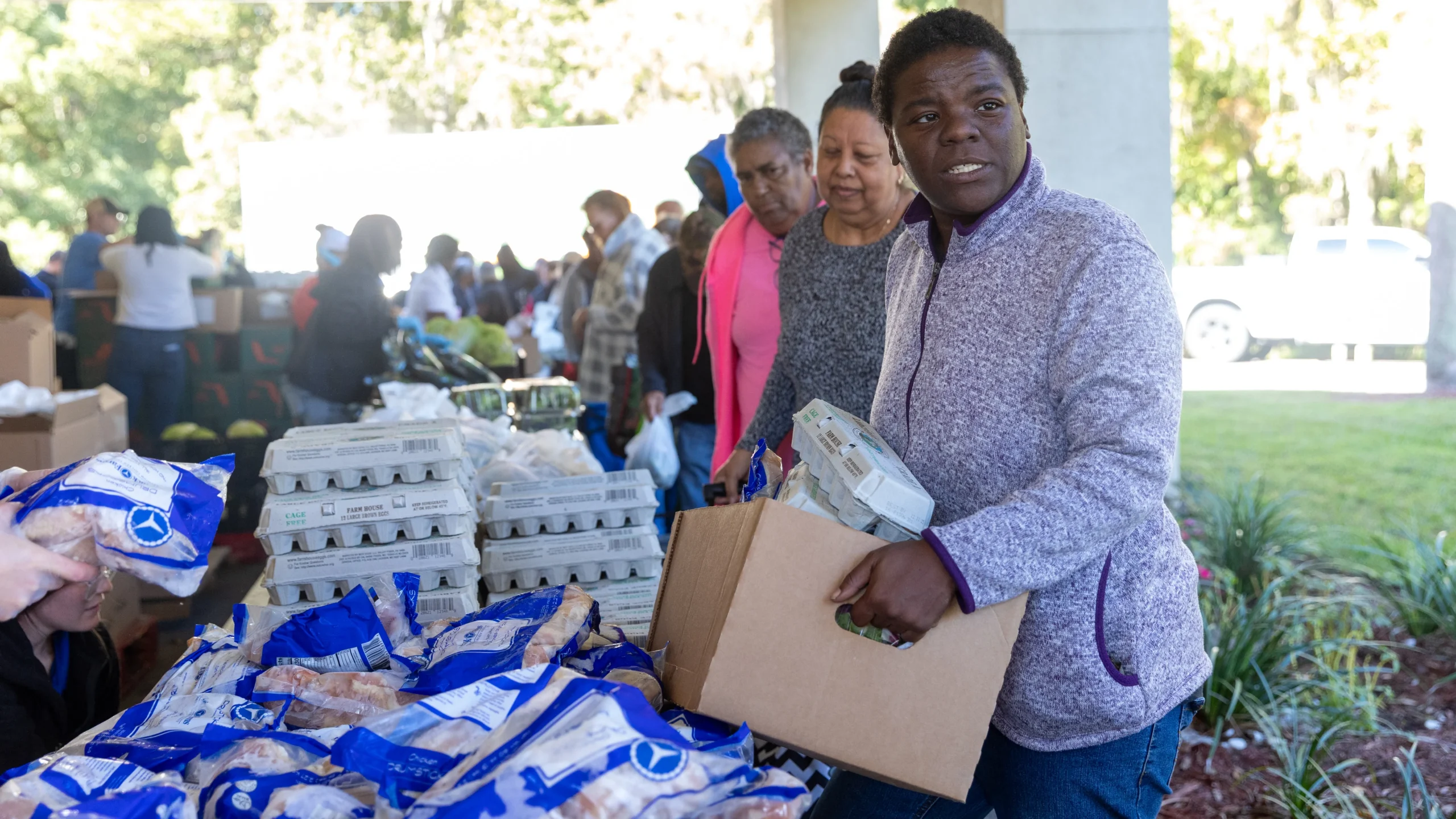 Georgia Patrick, a SNAP recipient, receives food during a distribution drive.