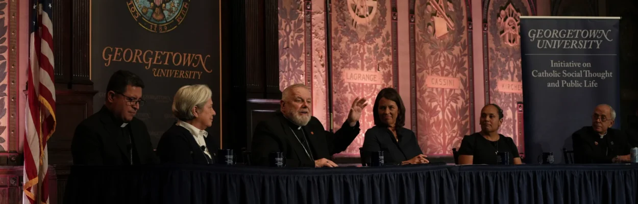 The archbishop of Miami, Thomas Wenski, raises his hand while addressing a crowd during a panel on immigration at Georgetown University in Washington.