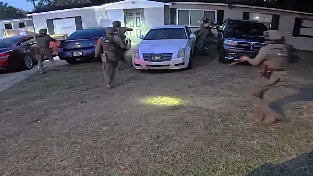 The Narcotics Overdose Death Investigations Unit rushes a house during a drug investigation.