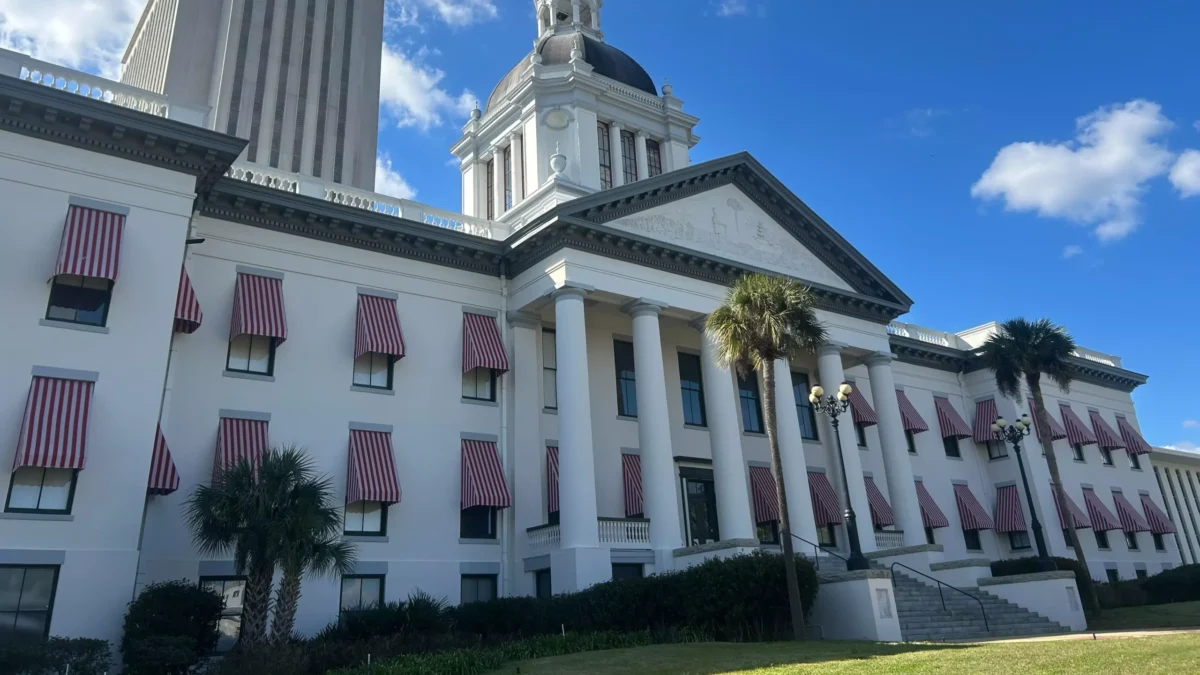 A picture of the Florida Old Capitol with the tower of the new Capitol rising in the background. Both are hit by the the sun.