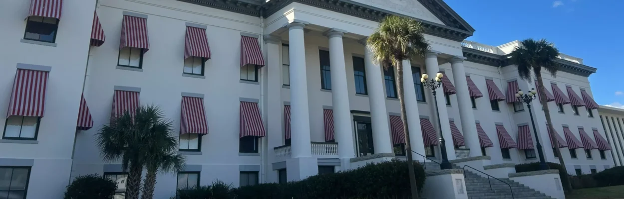A picture of the Florida Old Capitol with the tower of the new Capitol rising in the background. Both are hit by the the sun.