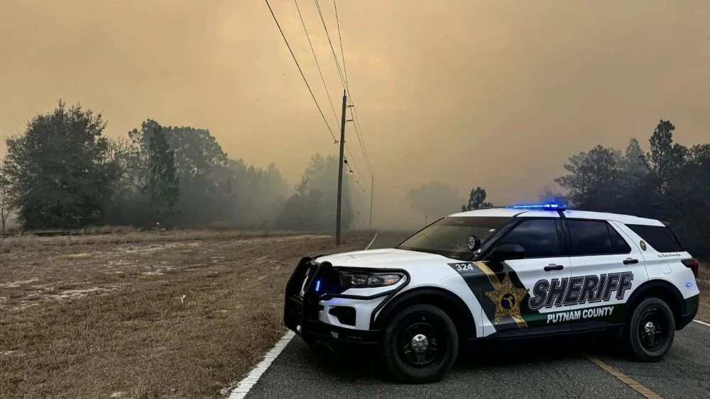 A police car surrounded by smoke from wildfires in Putnam County.