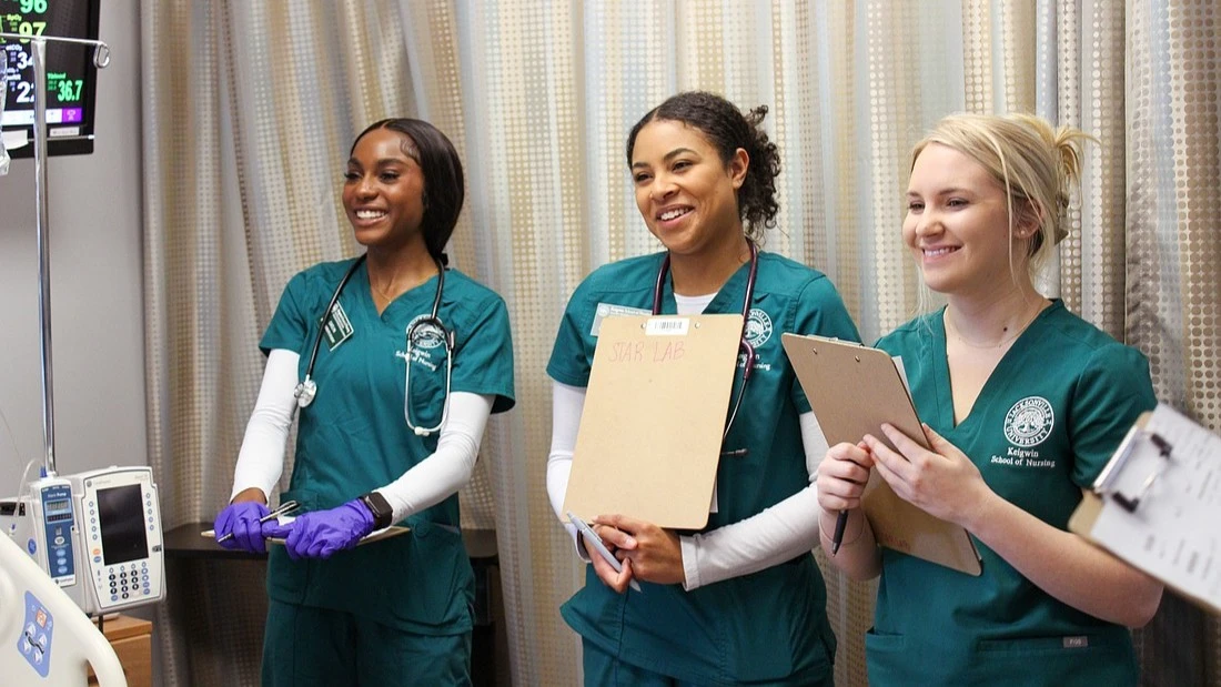 Three nursing students in scrubs
