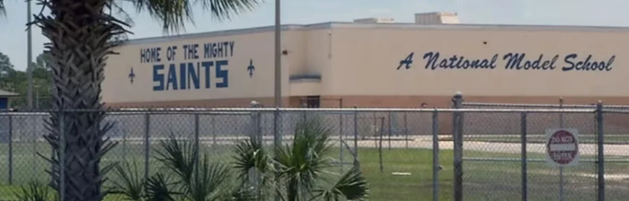 Sandalwood High School, shown behind a palm tree and fence.