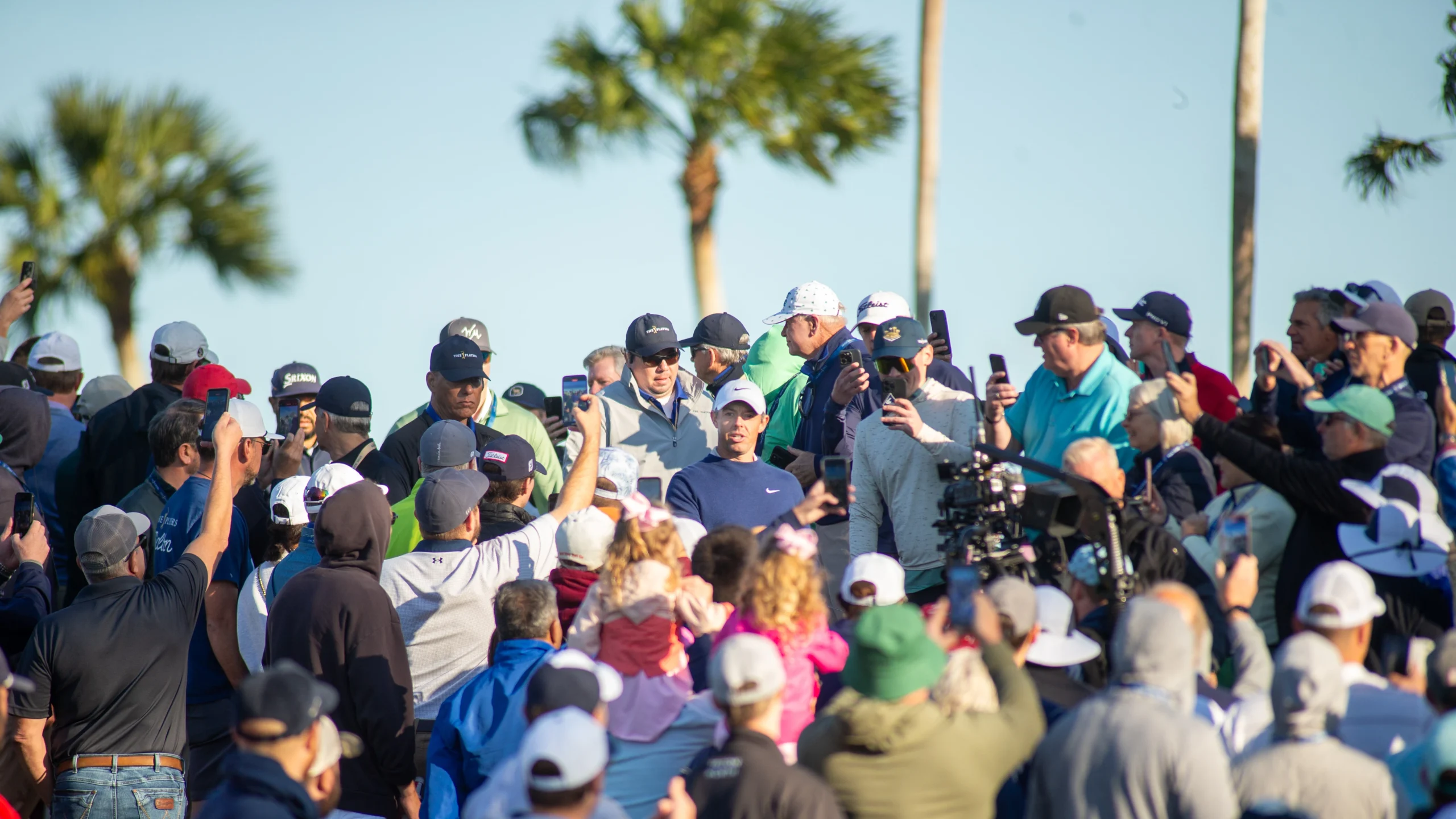 Golfer Rory McIlroy surrounded by sports fans.