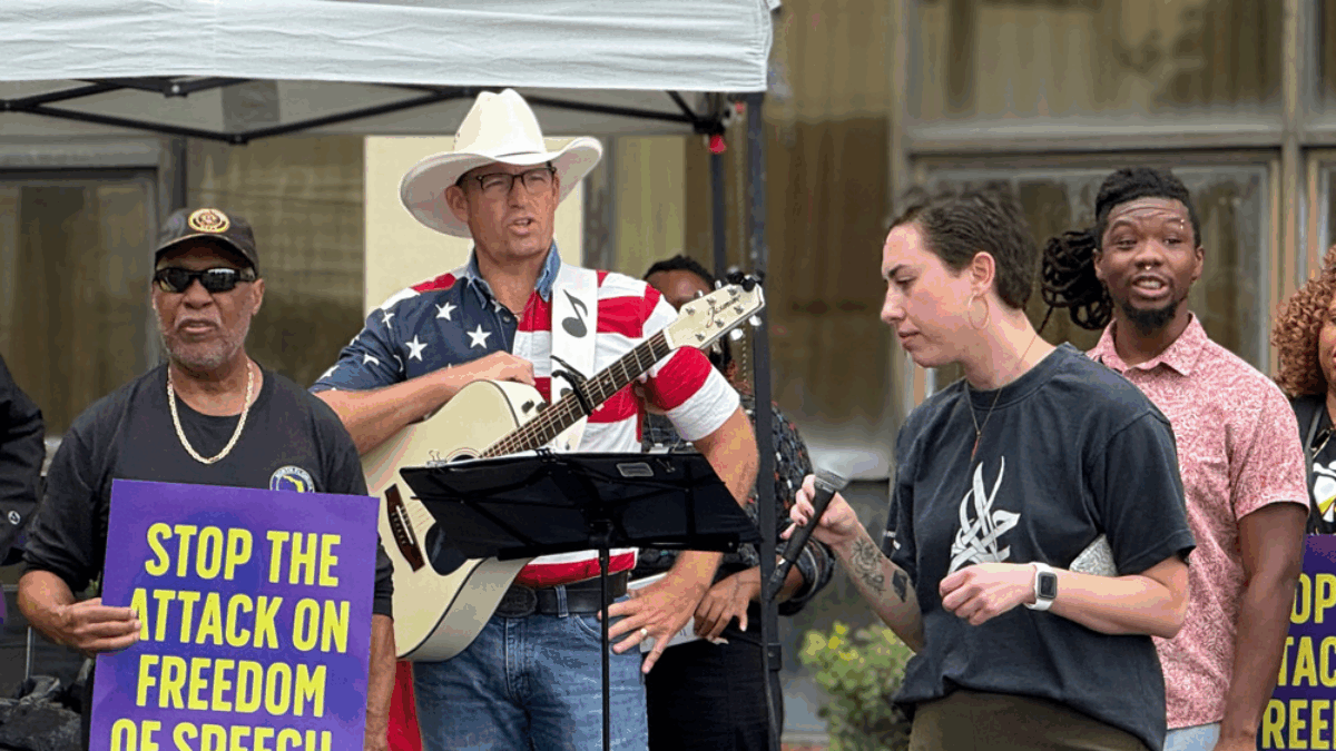 Mike Ludwick, who made a complaint about prayer at school board meetings, seen here holding a guitar and standing in front of the Duval Schools headquarters on Oct. 7, 2025.