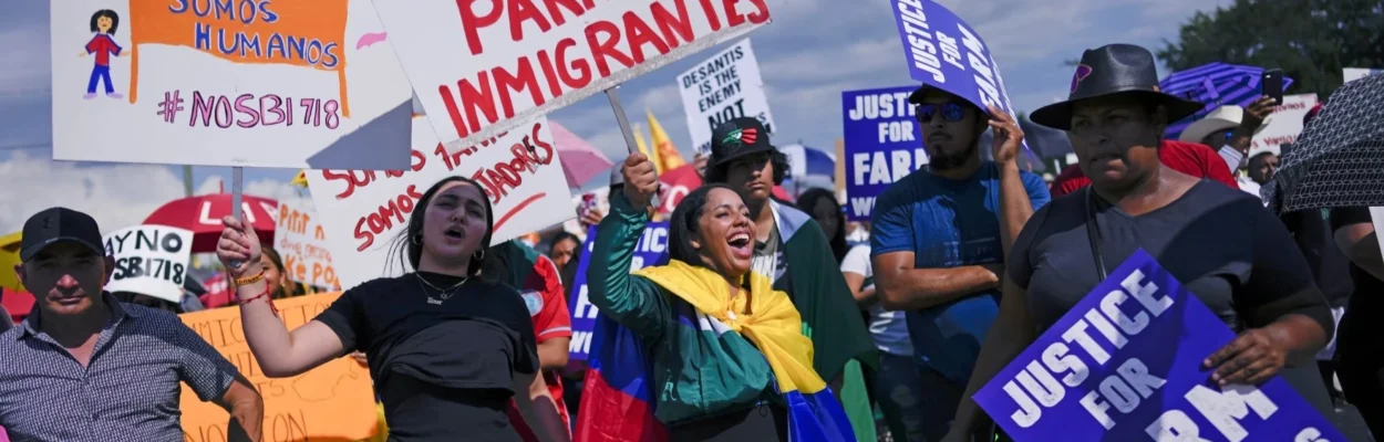 People carry signs to protest against Florida Senate Bill 1718, which imposed restrictions on undocumented immigrants.
