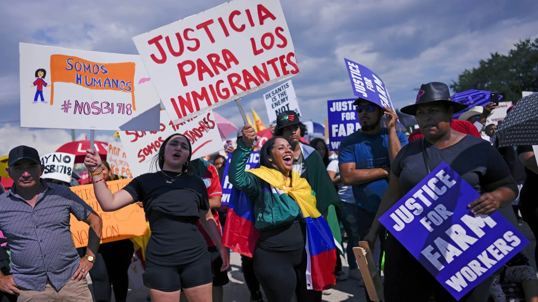 People carry signs to protest against Florida Senate Bill 1718, which imposed restrictions on undocumented immigrants.