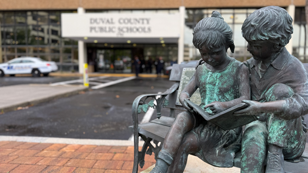A statue of children reading in front of DCPS headquarters.