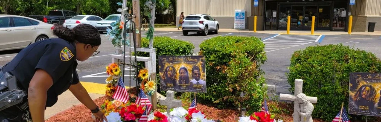 Corrections officer Mary Malcolm tends to a memorial at the Dollar General store.