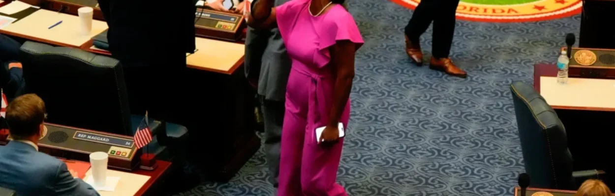 Angie Nixon walks while talking into a bright pink megaphone