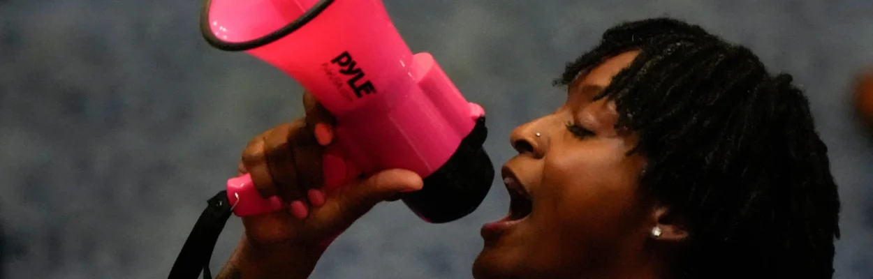 State Rep. Angie Nixon speaks with a megaphone on the House floor.