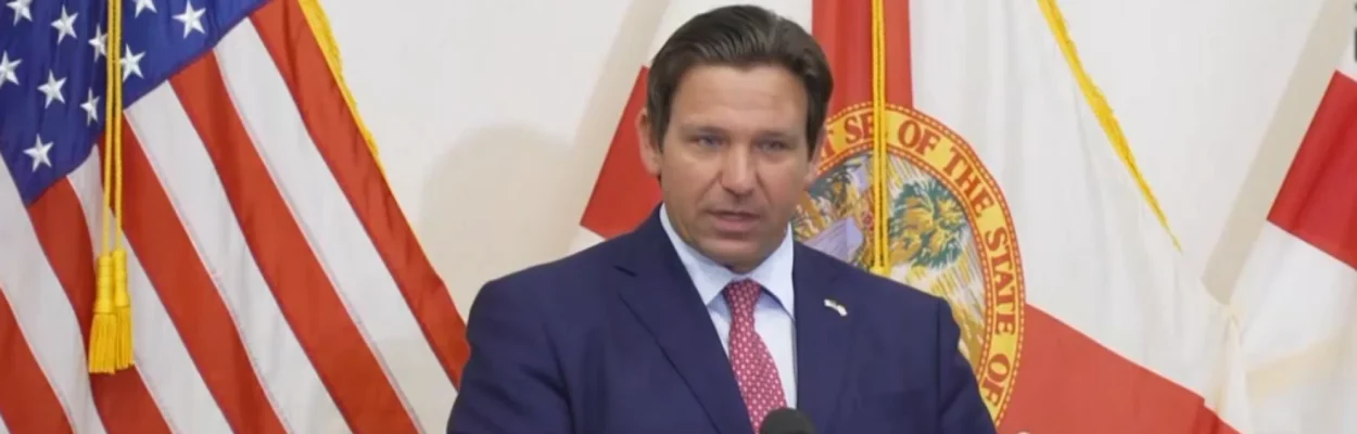 Gov. Ron DeSantis standing at a microphone as he calls for eliminating most property taxes.