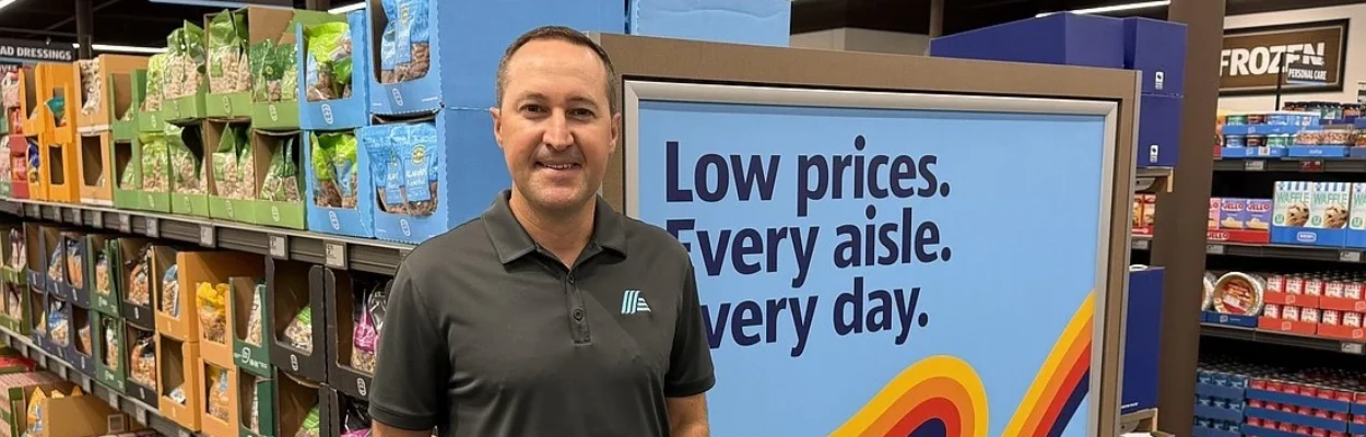 Aldi Regional Vice President JR Perry standing in front of a display case in the new Aldi store.