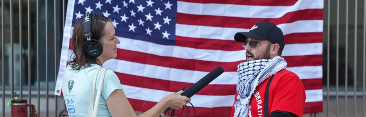 Elizabeth Caldwell holds a microphone while doing an interview.