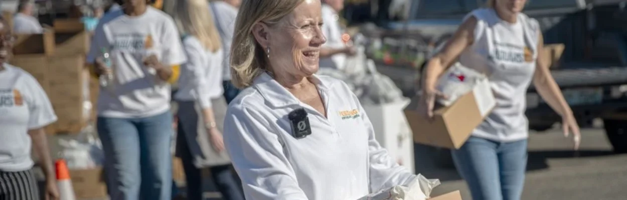 Susan King, president and CEO of Feeding Northeast Florida, holds a box during a food giveaway.