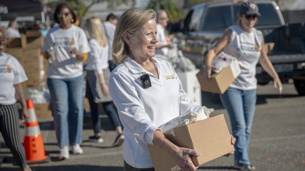 Susan King, president and CEO of Feeding Northeast Florida, holds a box during a food giveaway.