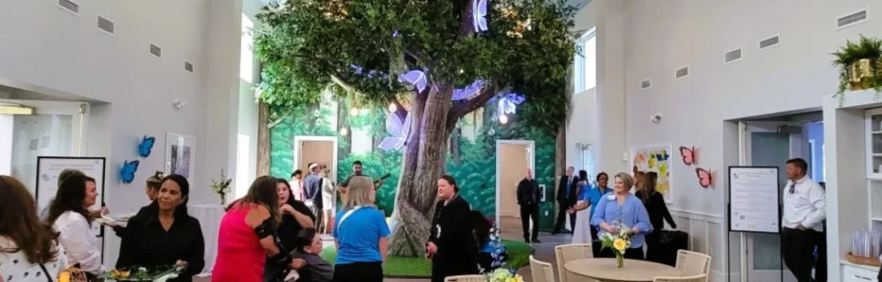 People crowd around a fake tree in the Dorion Family Pediatric Center at Community Hospice & Palliative Care in Mandarin