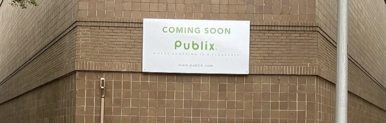 A sign on a building announces that Publix is coming soon.
