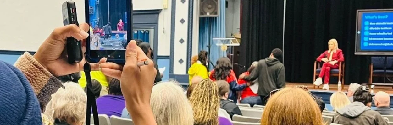 Mayor Donna Deegan sitting on a stage at a town hall meeting