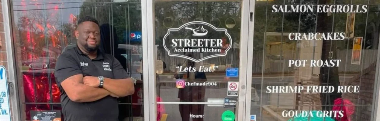 Johnathan Streeter, owner of Streeter Acclaimed Kitchen, stands in front of his restaurant with his arms crossed.