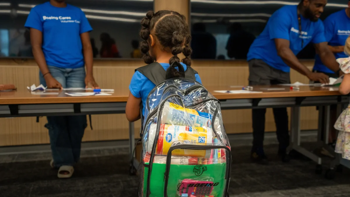 A student wears a backpack stuffed with supplies at the Boeing Jacksonville Back to School Giveaway.
