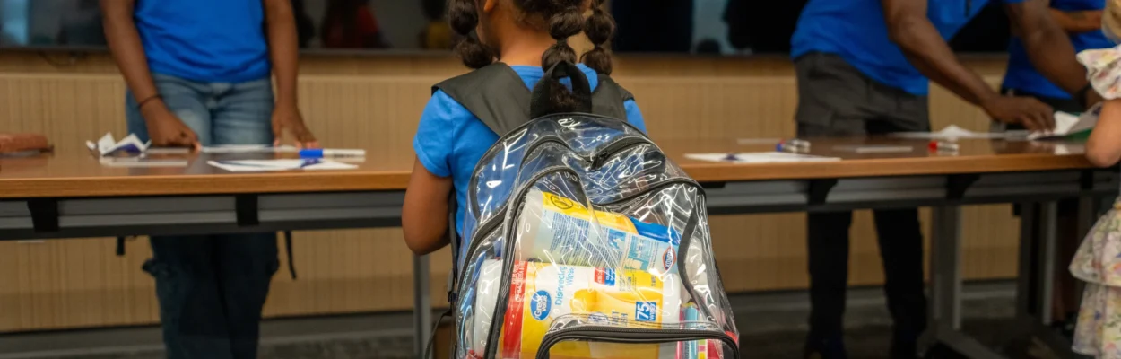 A student wears a backpack stuffed with supplies at the Boeing Jacksonville Back to School Giveaway.