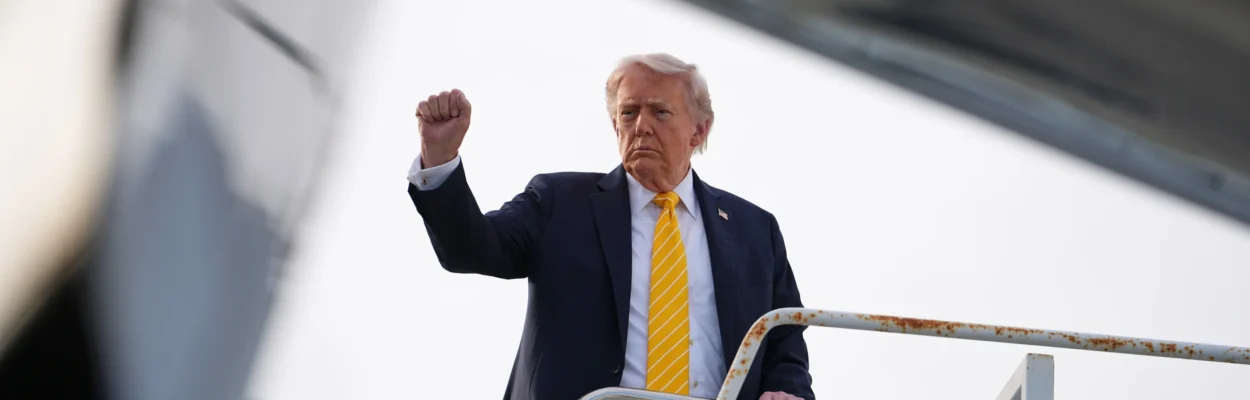 President Donald Trump raises a fist and boards Air Force One.