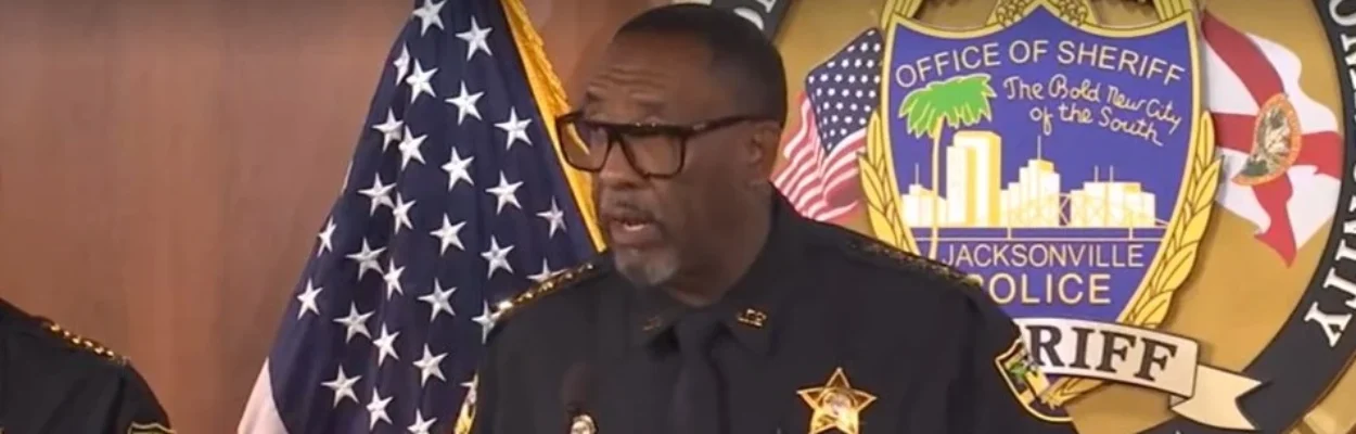 Sheriff T.K. Waters standing at a lectern as he announces the arrest of a police officer.