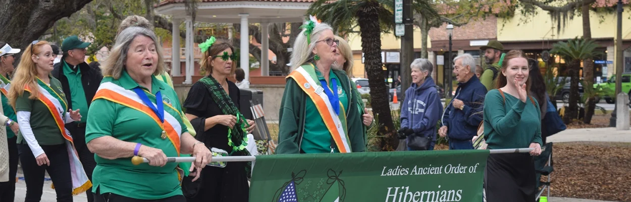 People dressed in green and holding banners march in the Romanza-St. Augustine's St. Patrick's Day Parade and celtic events in St. Augustine.