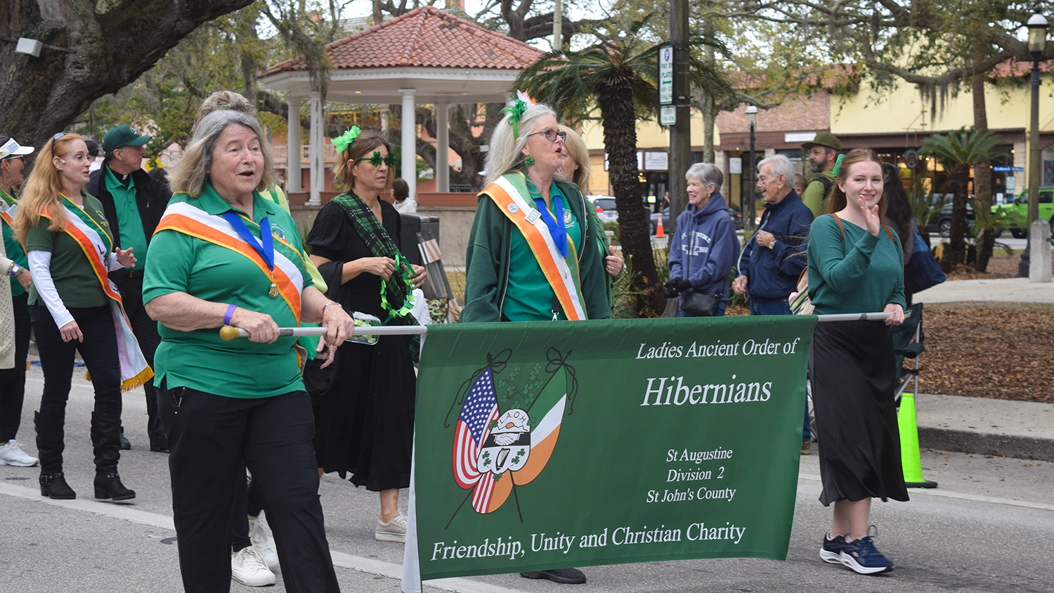 People dressed in green and holding banners march in the Romanza-St. Augustine's St. Patrick's Day Parade and celtic events in St. Augustine.