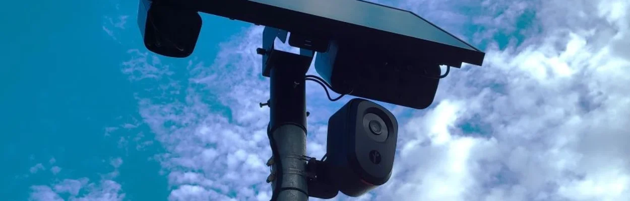 A Flock camera with a solar panel on top.