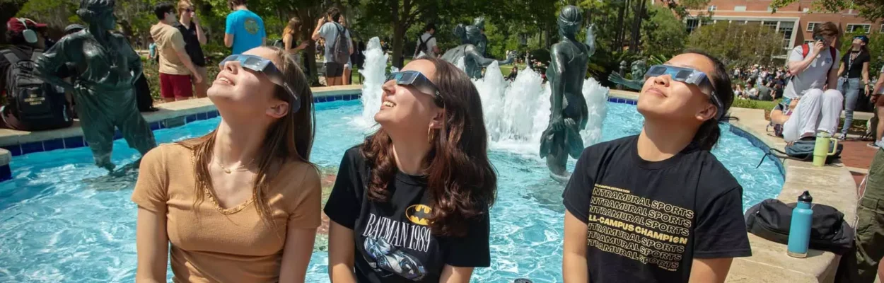 Students in glasses gaze toward the sky as Tallahassee witnesses a partial solar eclipse April 8, 2024.