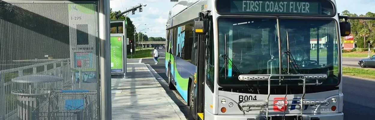 A JTA First Coast Flyer bus pulled over to the curb at a bus stop.