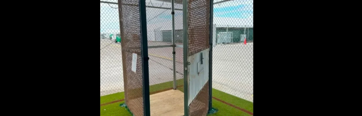An image of a cage used at "Aligator Alcatraz," a little bigger than a phone booth with the door swung open.
